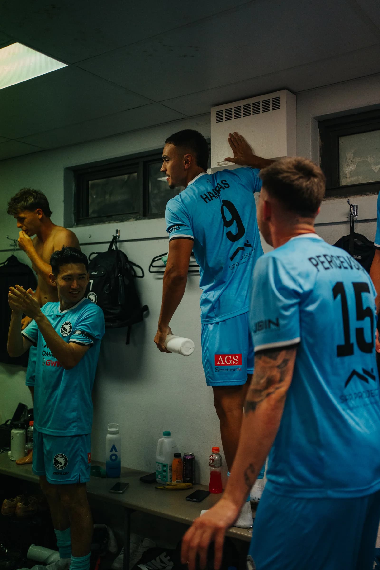Alen Harbas and Jamie Percevski among the players celebrating in the dressing room