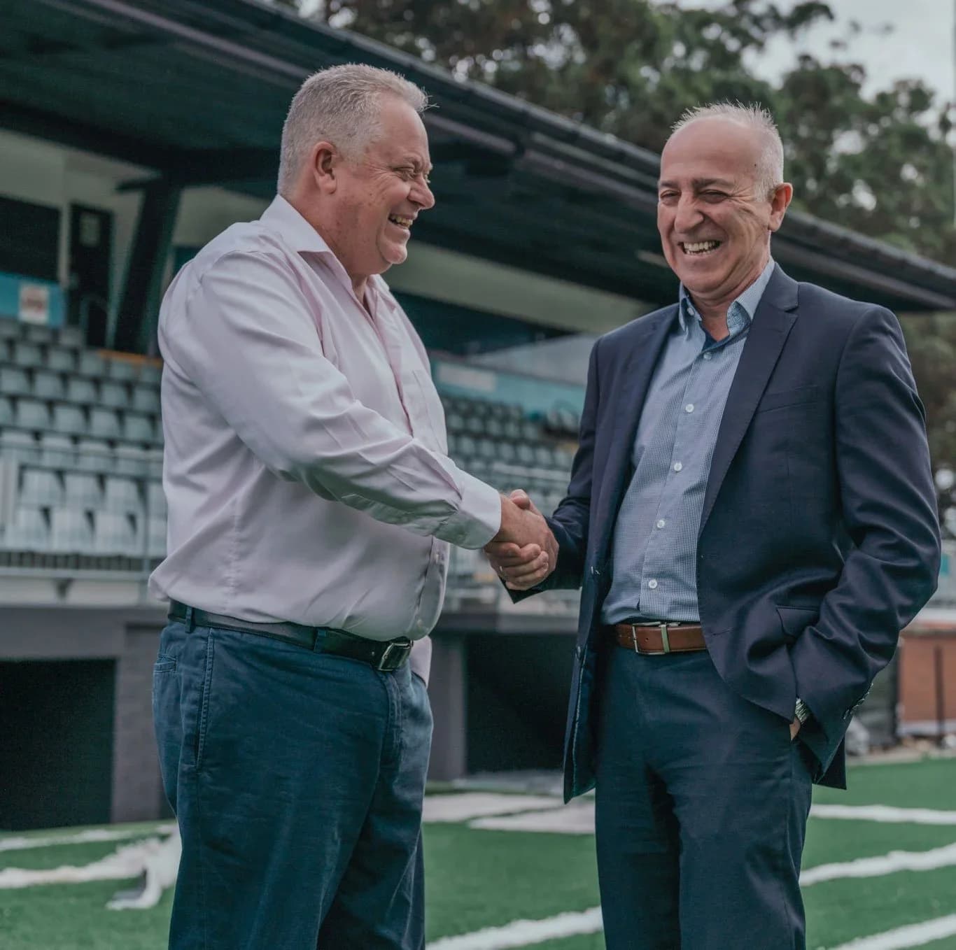 Two men shake hands on the pitch at Seymour Shaw to seal the Dominelli GWM sponsorship