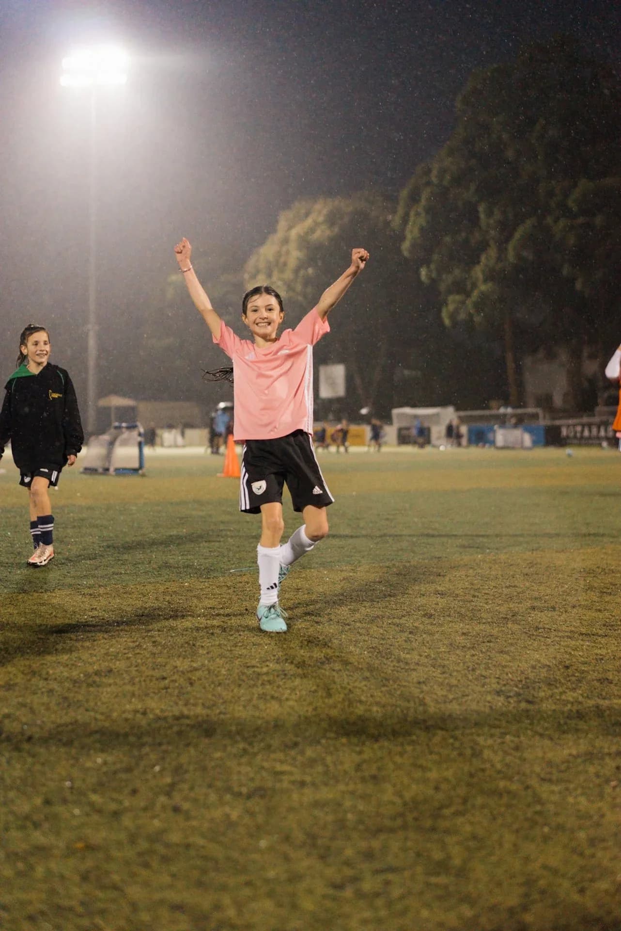 A girl celebrates on the pitch at night at the open day
