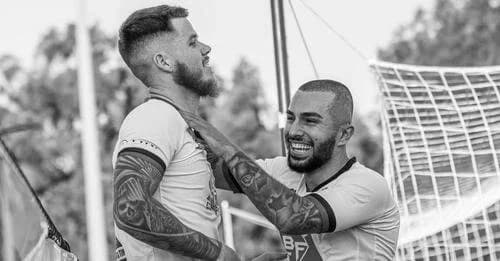 Two players embrace after the match, in black and white