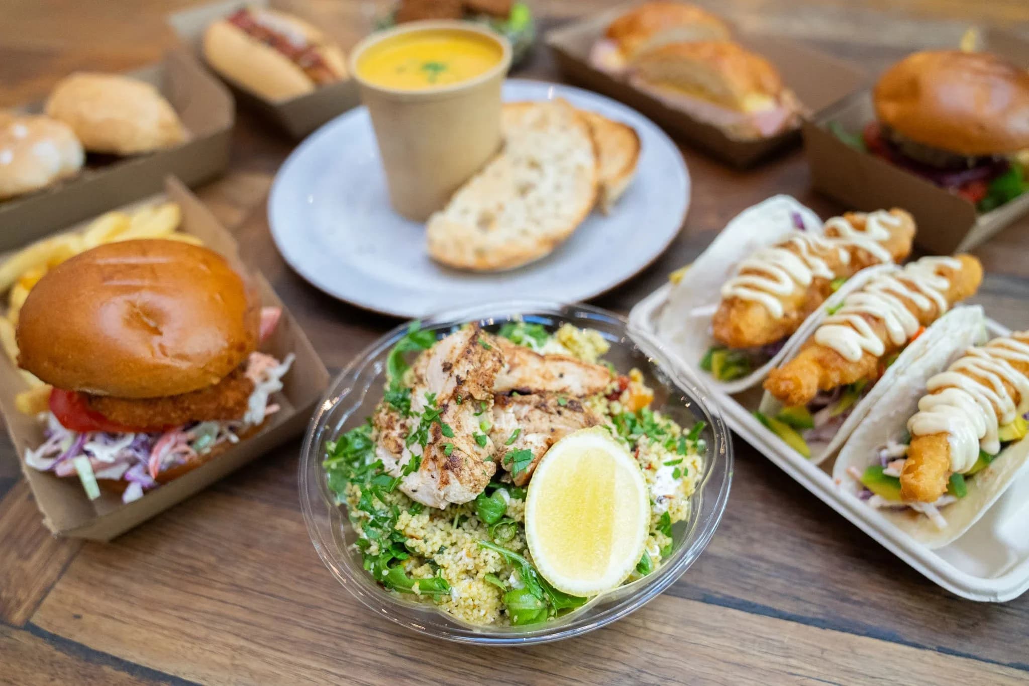 A spread of canteen food: burgers, tacos, a salad and soup