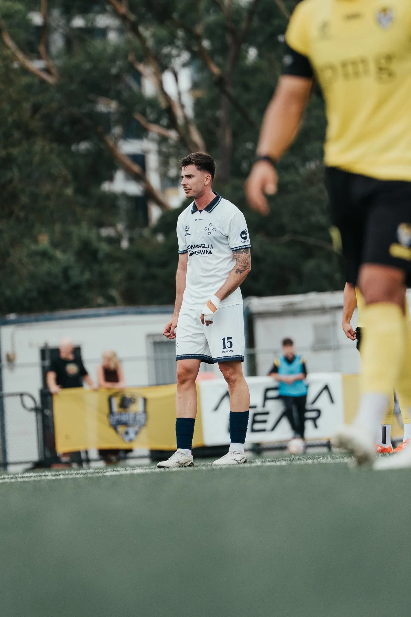 A Sharks player in white watches the play against NWS Spirit in yellow