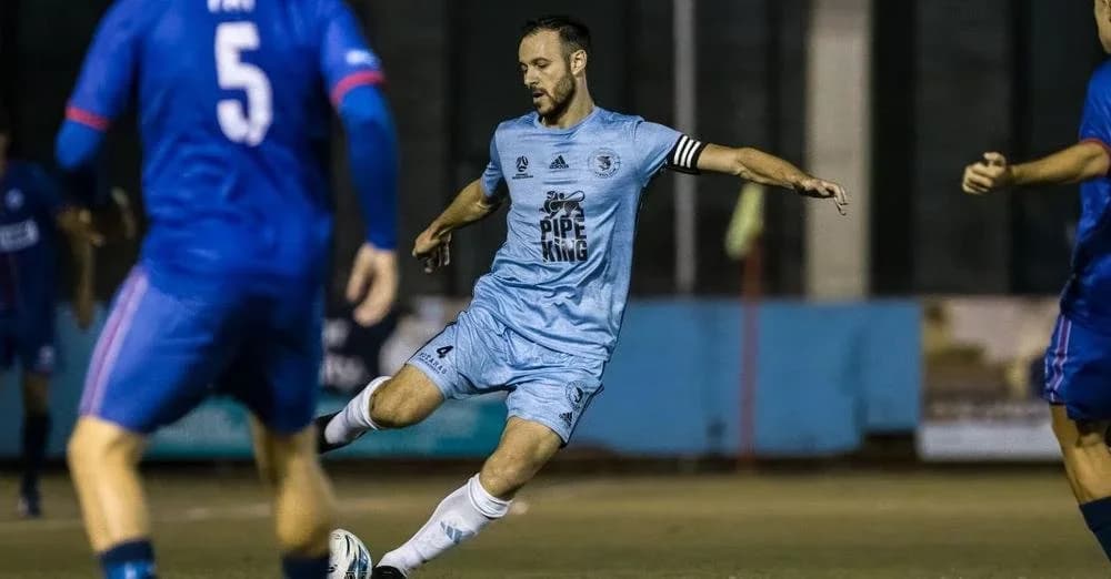A Sharks player in sky blue strikes the ball