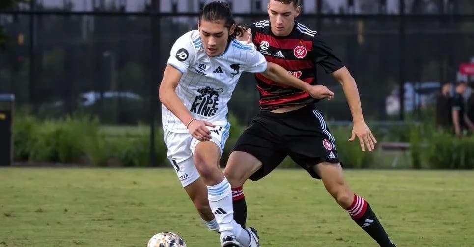 A Sharks player in white holds off a Wanderers player in red and black