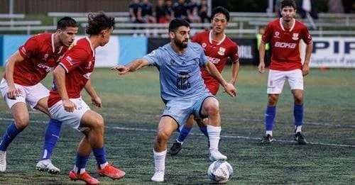 A Sharks player in sky blue dribbles between United 58 players in red