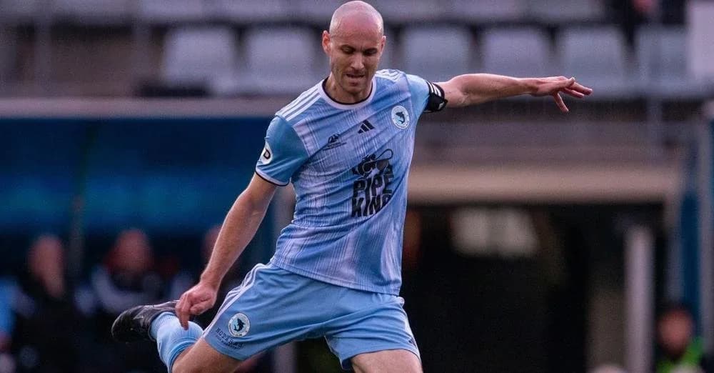 A Sharks player in sky blue strikes the ball