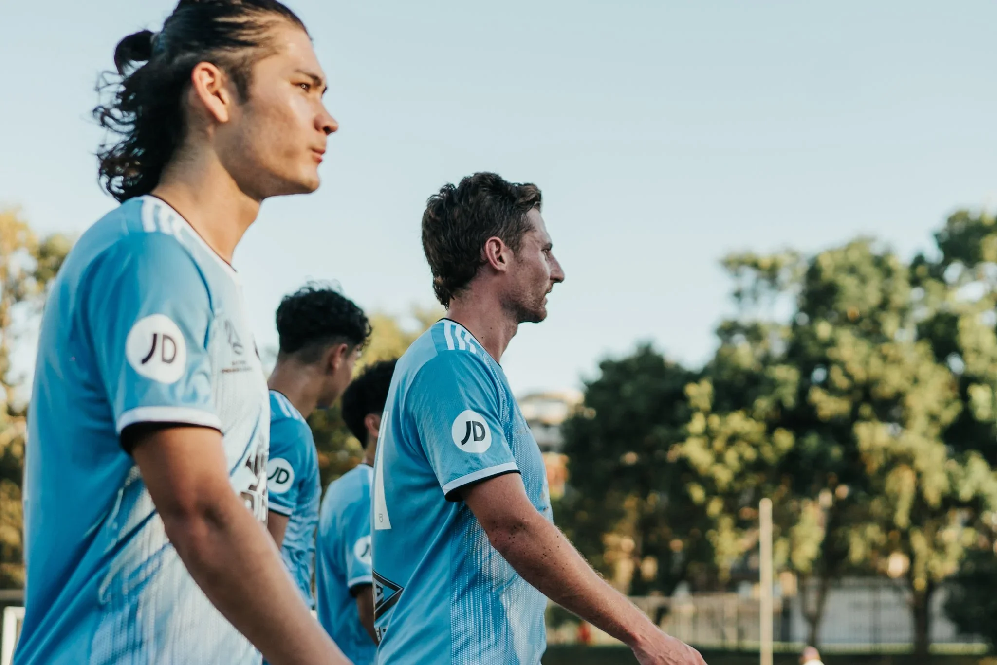 Two Sharks players in sky blue on the pitch before kick-off