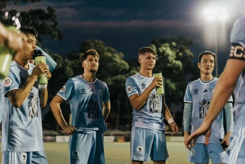 Sharks players in sky blue take a drinks break at night