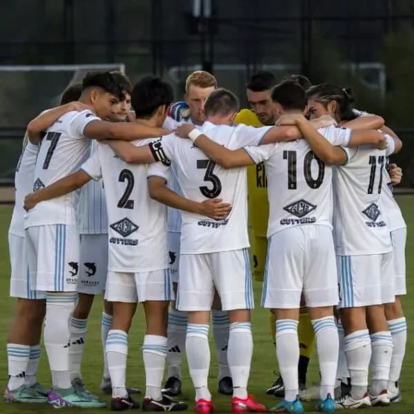 Sharks players in white huddle before the match against Olympic