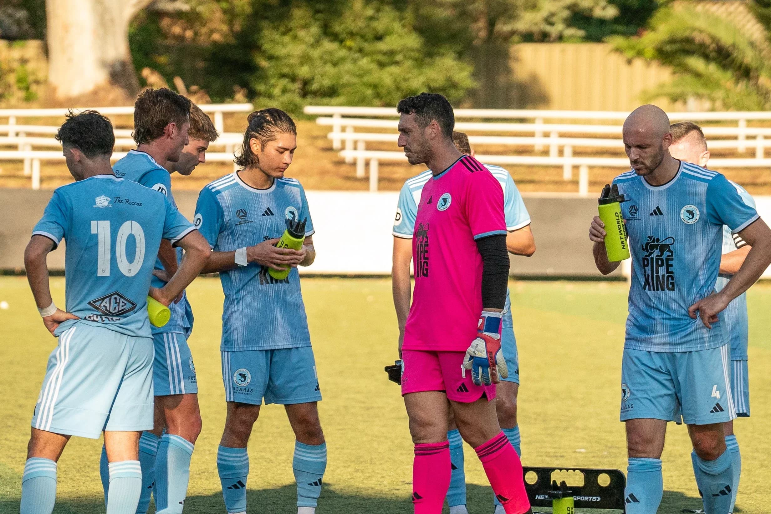 Sharks players, including the goalkeeper in pink, gather after the match against APIA