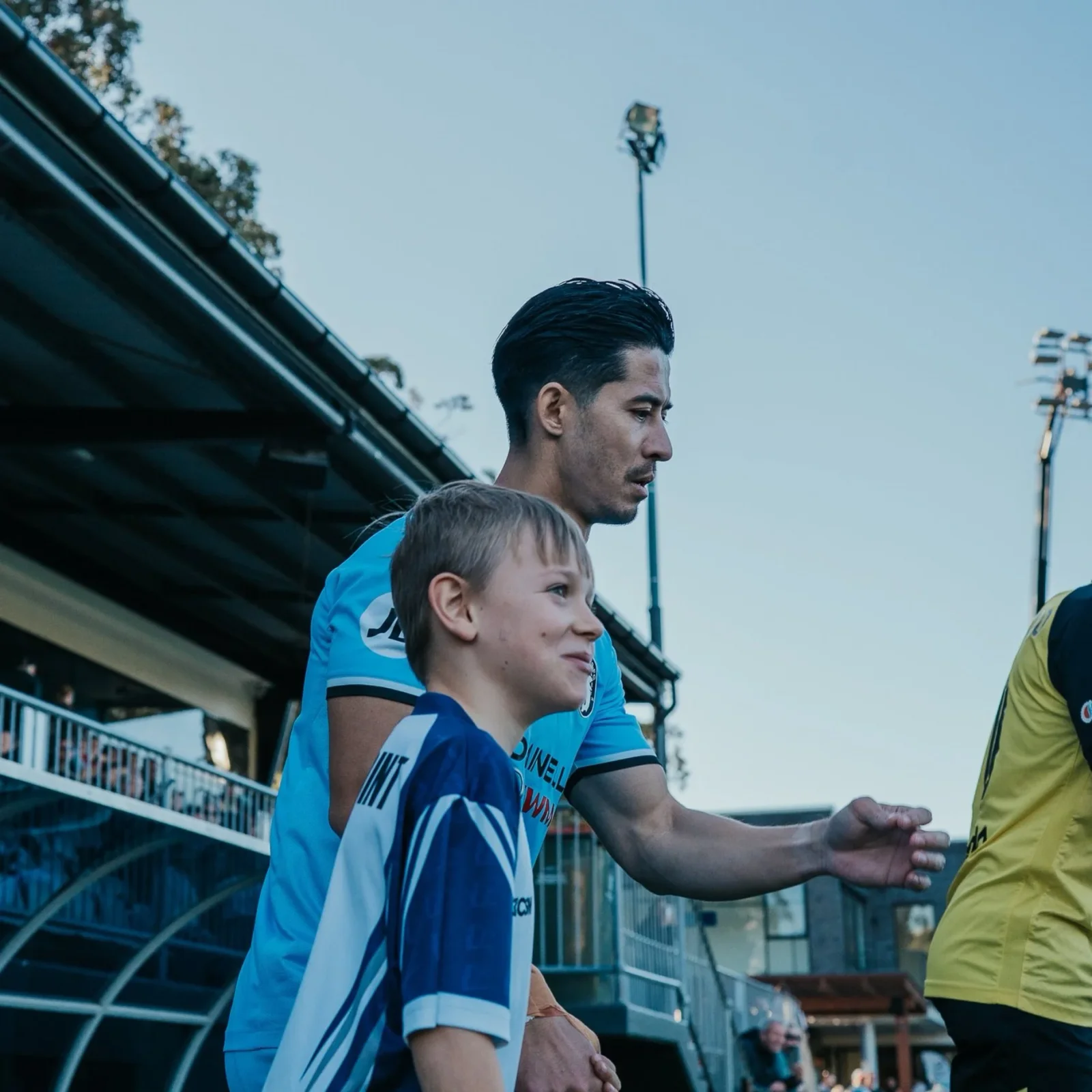 Brendan Gan with a young fan in a Sharks shirt in the stand