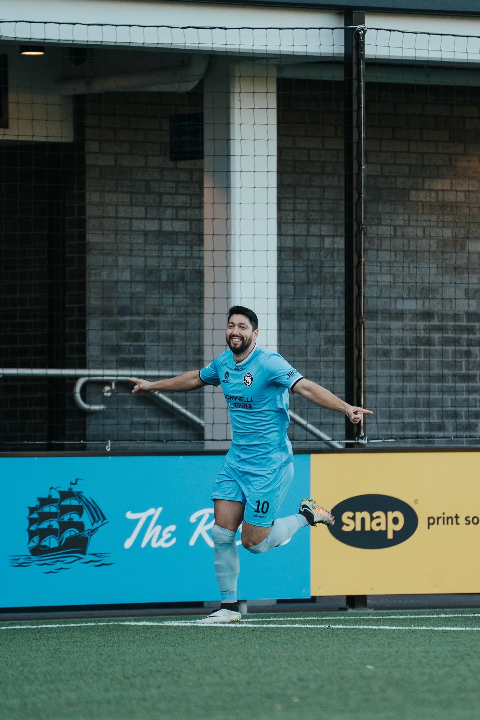 A Sharks player celebrates in front of the advertising boards against St George