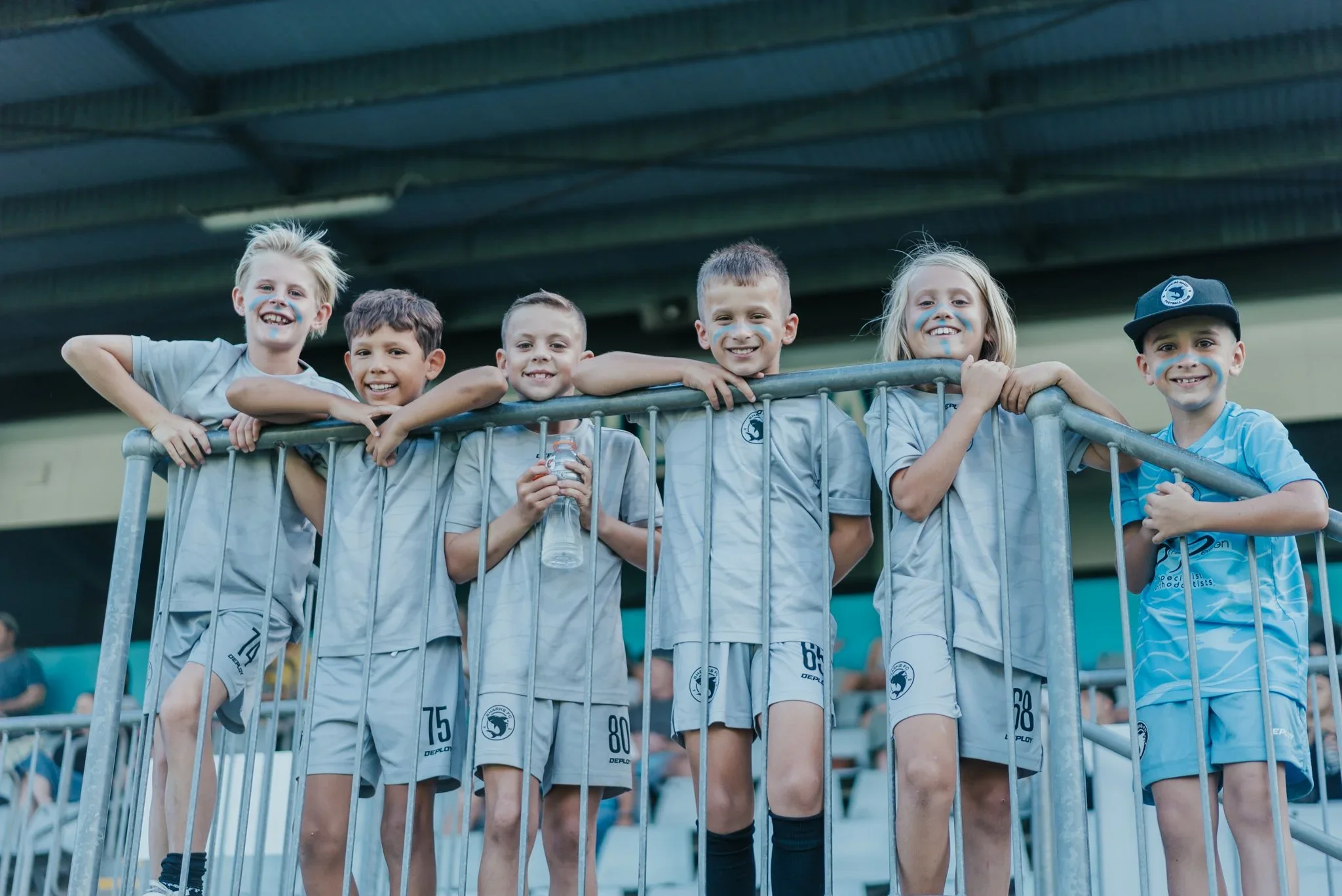 Young fans in Sharks shirts line the fence of the new grandstand