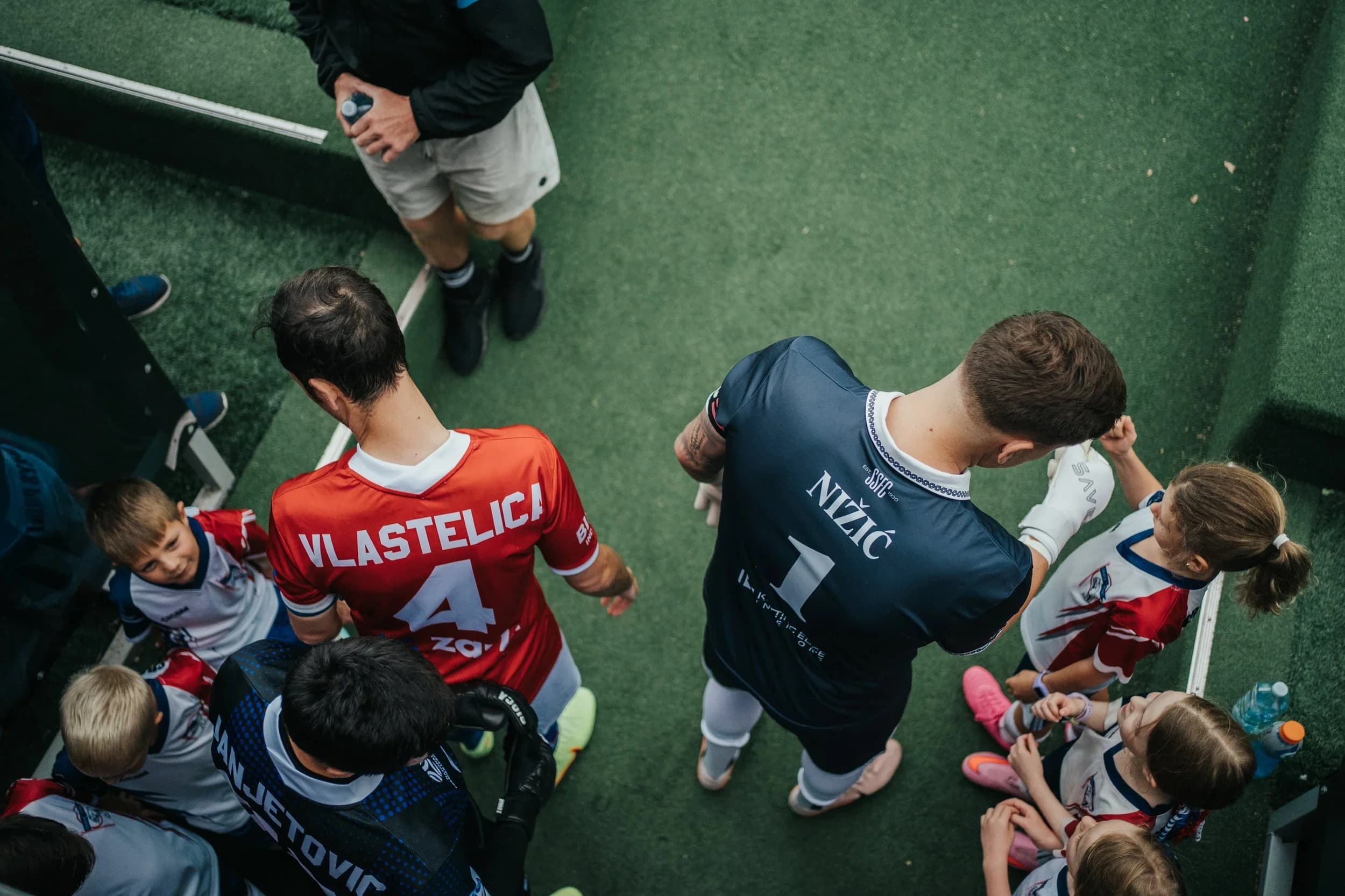 A Sharks goalkeeper and junior mascots in the tunnel before kick-off, seen from above