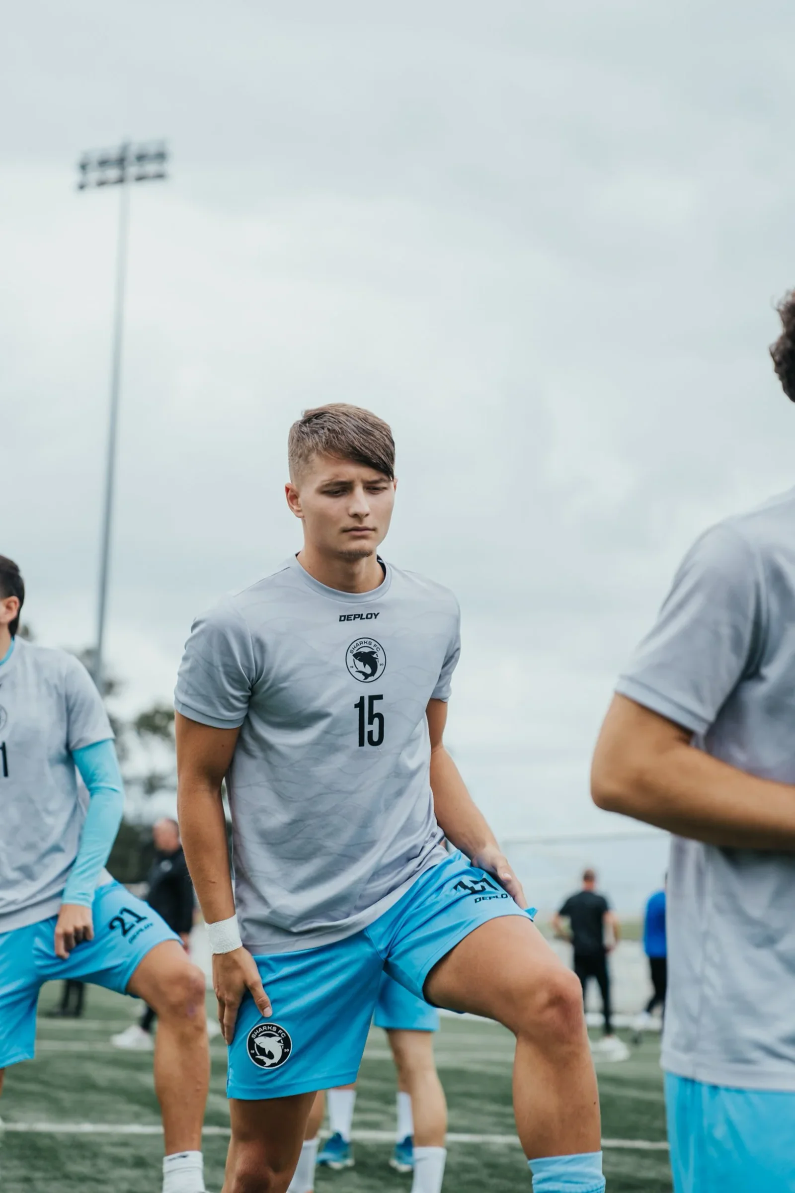 Sharks players in grey warm-up tops walk across the pitch