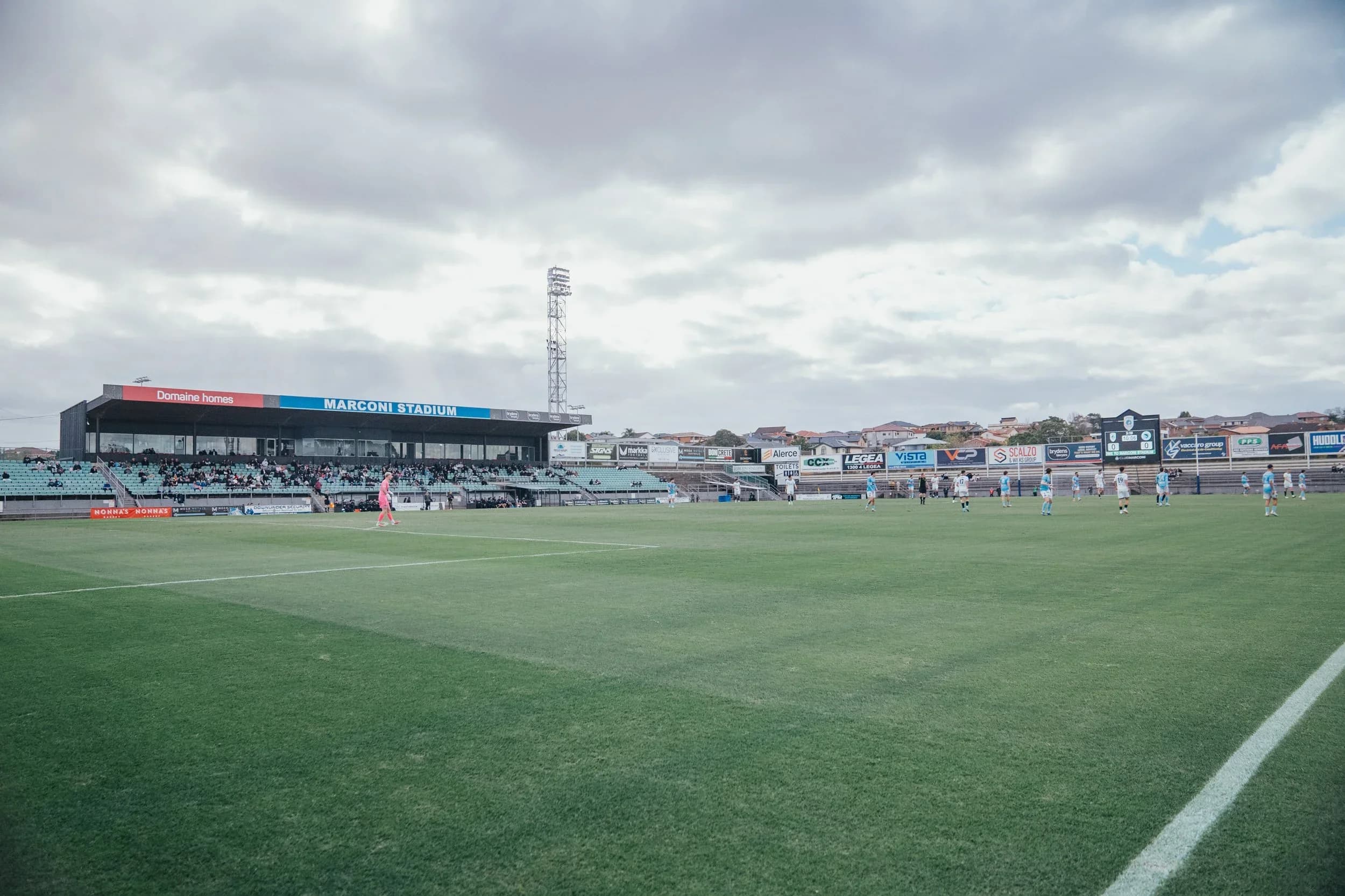 The pitch and grandstand at Marconi Stadium under a cloudy sky