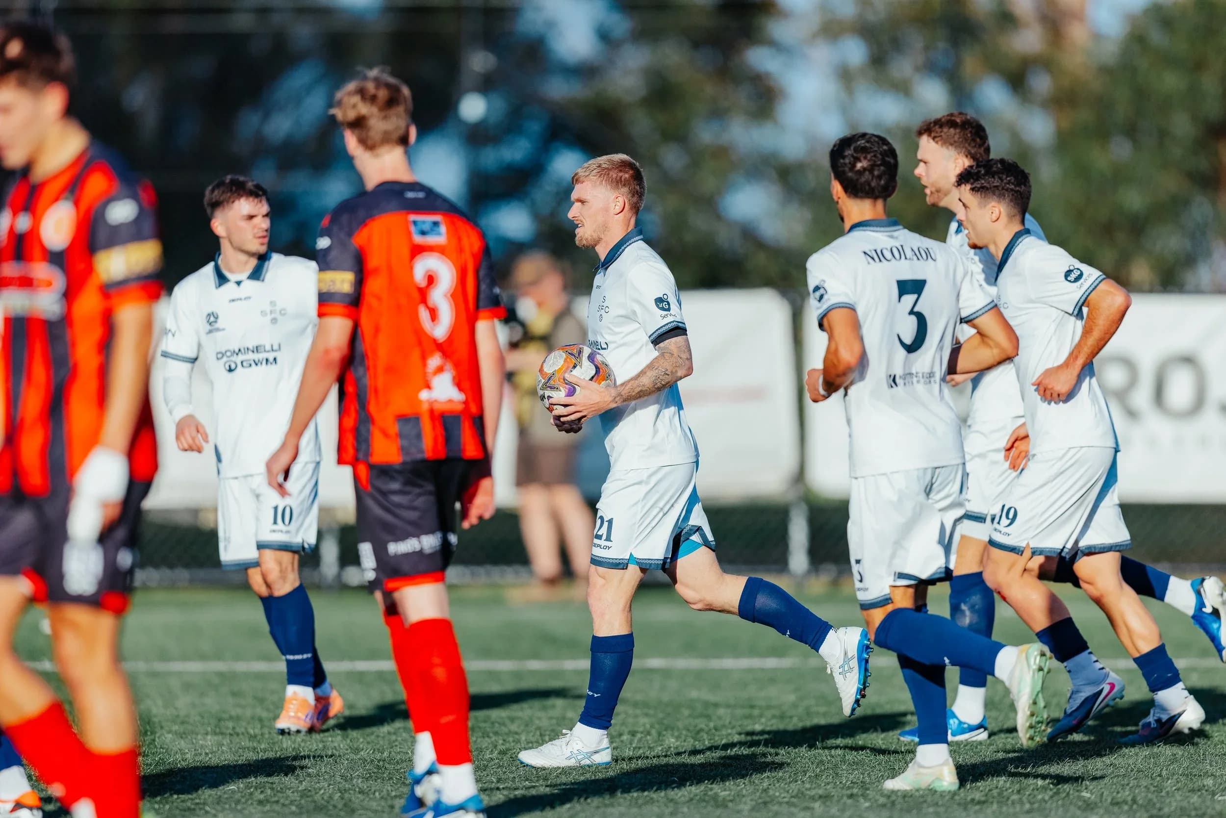 Sharks players in white celebrate a goal against Rockdale