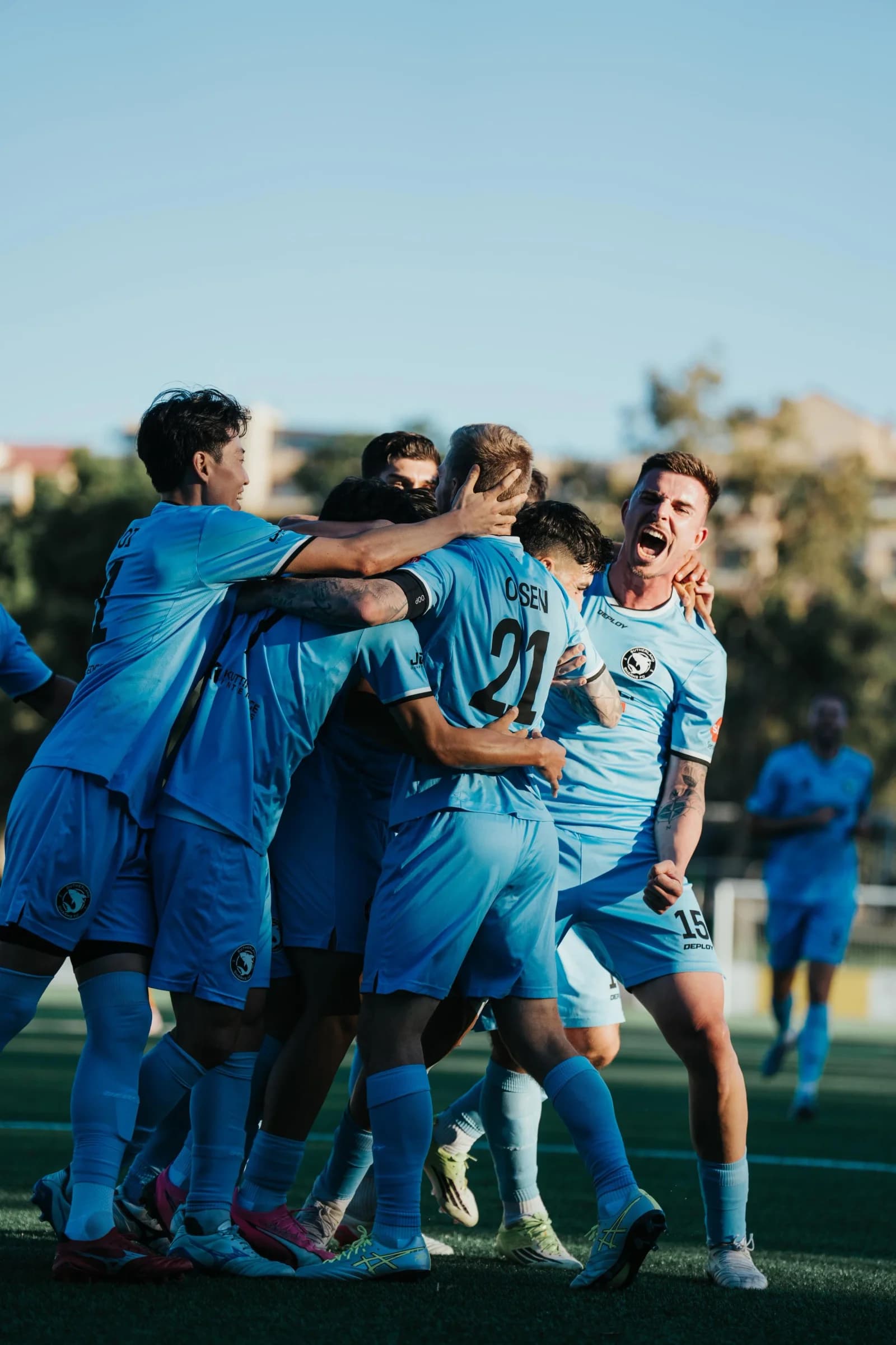 Sharks players embrace to celebrate a goal against Rockdale