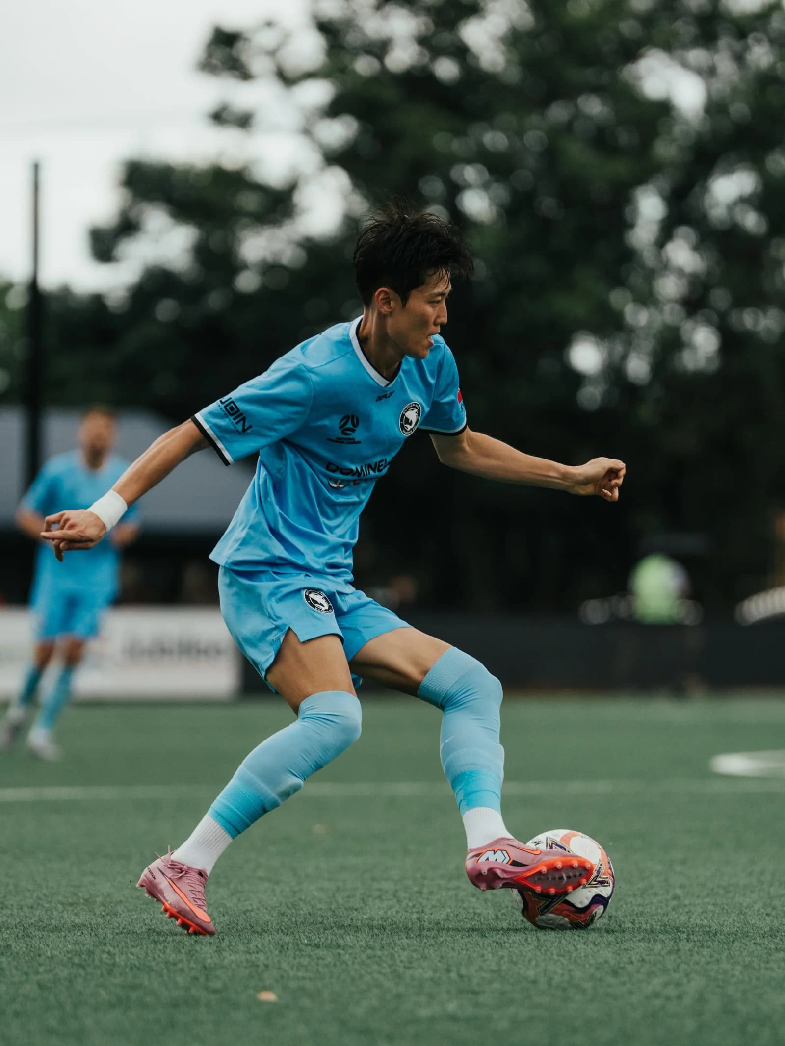 A Sharks player in sky blue strikes the ball at Wanderers
