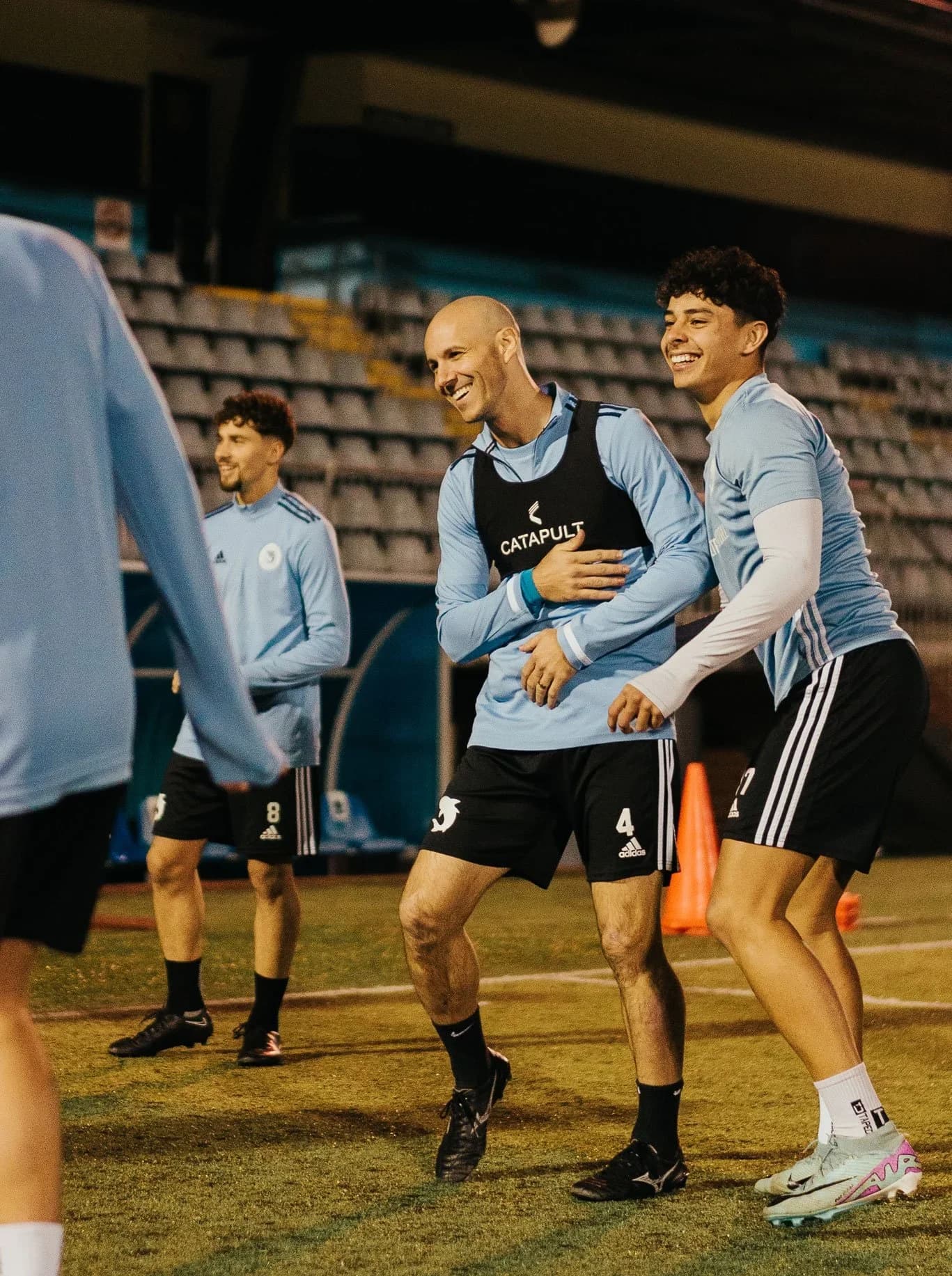 Sharks players laugh together during a training session at night