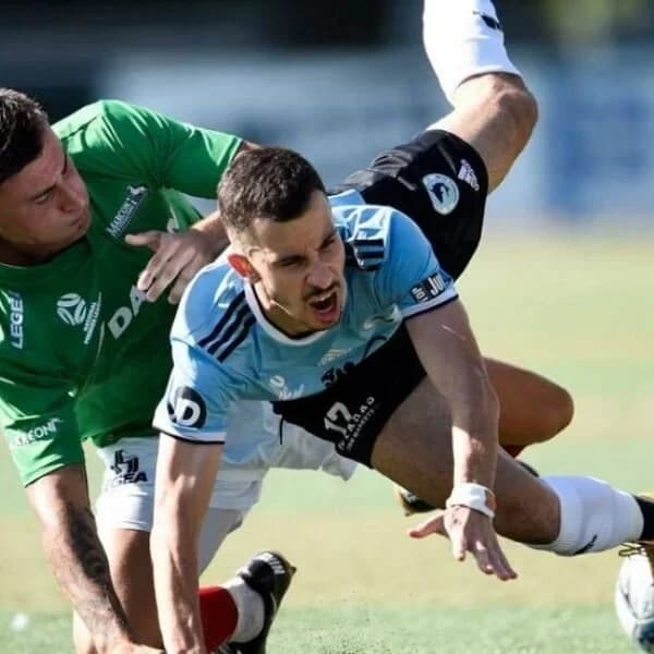 A Sharks player goes to ground in a challenge with a goalkeeper in green